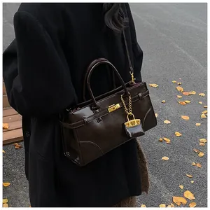 Klassische dunkelbraune Leder-Tragetasche mit goldenem Drehverschluss und Anhänger