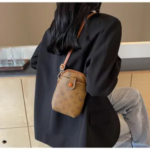 Close-up of vintage brown monogram pattern leather phone bag with gold metal buckle hardware