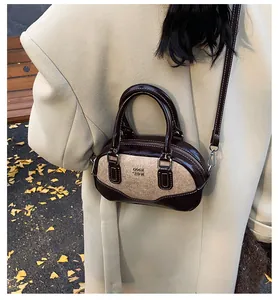 Retro mini bowling bag detail featuring brown patent leather and tweed contrast texture
