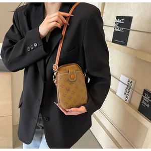 Brown vintage monogram crossbody phone bag styled with a black blazer on a model