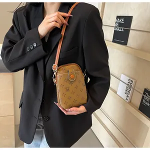 Close-up of vintage brown crossbody phone bag with FW monogram floral pattern