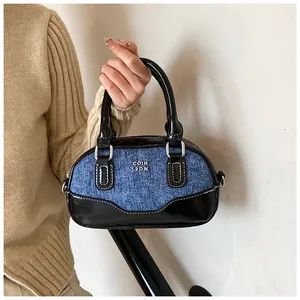 Detailed macro of the vintage contrast denim bowling bag with glossy black trim
