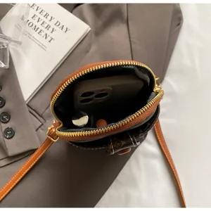 Close-up of vintage monogram mini phone bag with orange zipper and luxury leather strap