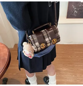 Borsa a tracolla a quadretti stile British con orsetto di peluche indossata da modella