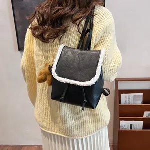 Retro-Rucksack aus schwarzem PU-Leder mit weißem Kunstfellbesatz und braunem Teddybär-Anhänger
