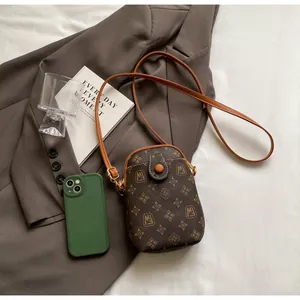 Flat lay of vintage monogram mini crossbody bag showing refined printing and round clasp detail