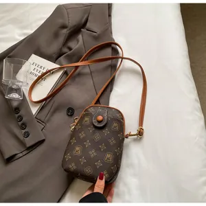 Detail of vintage monogram shell bag featuring retro patterns and leather button strap