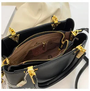 Internal view of black leather tote bag with gold zippers and organized compartments