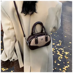 Close-up of retro tweed patchwork bowling bag worn by model in autumn street setting