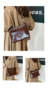 Detail view of dark brown oil wax leather shoulder bag with silver hardware and adjustable strap