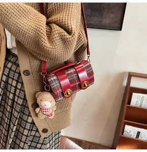 Dettaglio della borsa a tracolla vintage in tweed scozzese rosso con fibbia dorata