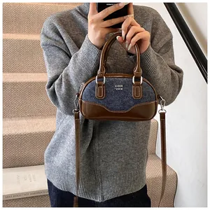 Detail view of vintage denim and brown leather bowling bag with silver metal hardware