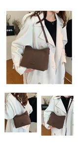 Detail view of brown matte suede hobo bag with polished leather strap and metal buckle