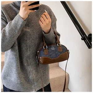 Detail of vintage denim and brown leather contrast bowling bag with silver hardware