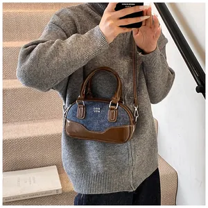 Close-up of retro color-block bowling bag in blue denim and brown leather details
