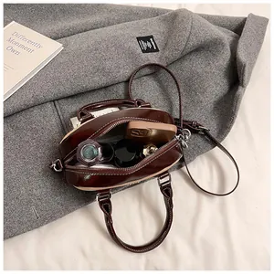 Detailed interior of dark brown patent bowling bag showing space for phone and makeup