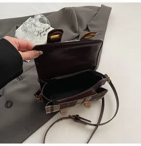 Dettaglio della tasca interna con cerniera e della fodera marrone liscia della borsa a quadri