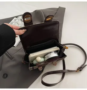 Dettaglio dell'interno della borsa a tracolla marrone vintage e fibbie in metallo dorato