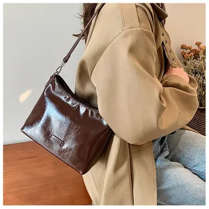 Model wearing dark brown vintage leather underarm bag with minimalist shoulder strap