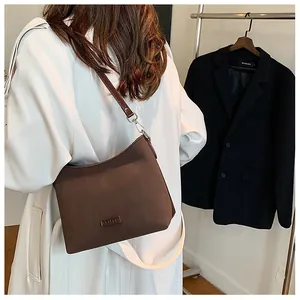 Deep brown suede shoulder bag detail showing minimalist design and silver buckle