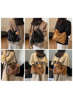 Detail view of large retro hobo bag with wide shoulder strap and cute bear charm pendant
