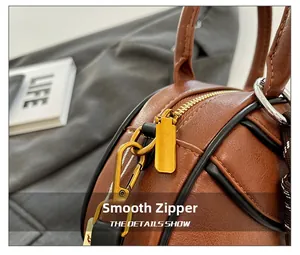 Macro shot of smooth gold zipper hardware on caramel leather bag with pebble texture