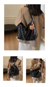 Detailed views of a black oversized tote bag featuring a plush bear charm and striped ribbon