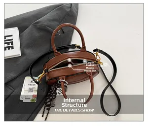 Detail of a brown leather bag showing internal pockets, zipper and main storage space