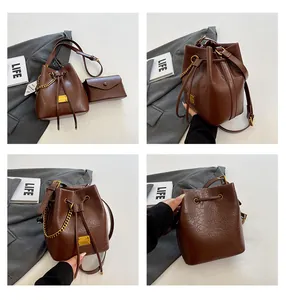 Dettagli della borsa a secchiello in pelle marrone scuro con coulisse e catena dorata