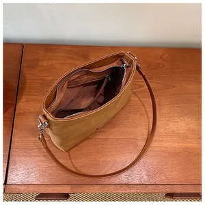 Detailed interior view of a brown suede hobo bag with zipper and silver hardware details