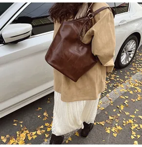 Bruine tote bag met vierkante stiksels gedragen op de schouder in een herfstsetting