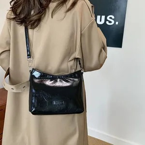 Minimalist black glossy shoulder bag for women with silver hardware and adjustable strap