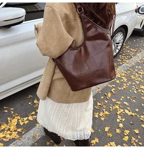 Detail van vintage bruine hobo tas met patchwork textuur in een herfstachtige straat