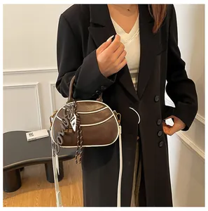 Detail of retro semi-circular crossbody bag in dark coffee with contrast white trim
