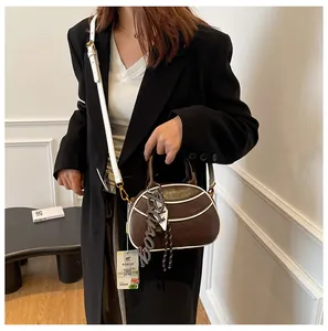 Detail of vintage bicolor baseball bag with leather charm and crossbody strap