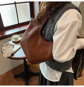 Detailopname van de donkerbruine gewatteerde shopper met leertextuur en gespriem