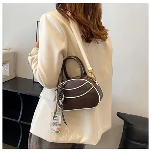 Detail of color-block baseball style bag with white piping and golden hardware