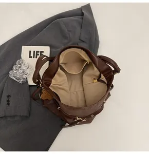 Detail view of large brown tote bag with premium leather texture and golden zippers
