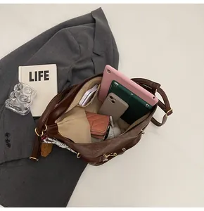 Spacious interior of brown tote bag holding a tablet, smartphones and essentials