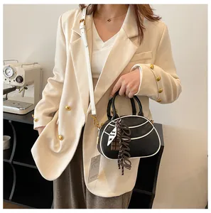 Detail of black semi-circular crossbody bag with white contrast trim and cute charms