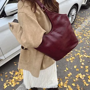 Grote bordeauxrode lederen tote bag met geometrische stiksels in een herfstsetting