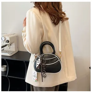 Detail view of contrast black and white baseball bag with multiple decorative pendants