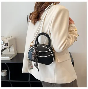 Mini baseball-style bag with black and white contrast colors and chocolate charm detail