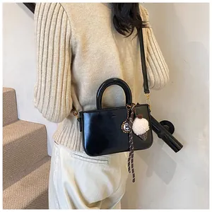 Détail du petit sac noir en similicuir avec un accessoire de breloque boule de glace