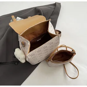 Vue de dessus du sac à dos beige à motif chien avec pochette interne et pendentif nuage
