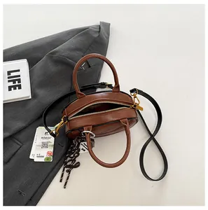Close-up of brown PU leather bag with lychee texture and golden zipper detail