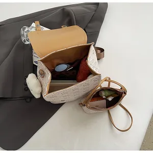 Détail d'un ensemble de sacs crème avec imprimé Snoopy, montrant l'espace de rangement