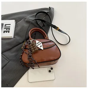 Detailed top view of a brown vintage baseball bag with gold hardware and creative charms