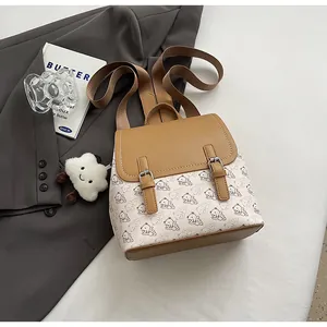 Détail d'un mini sac à dos avec imprimés d'ours, lanières en cuir brun et breloque nuage