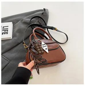 Detail of vintage brown baseball bag with chocolate charm and textured matte finish